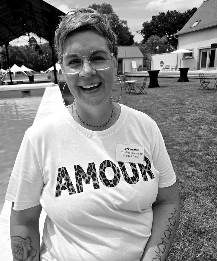 Stéphanie, wedding planner al'infini event, souriante au bord d'une piscine de domaine de mariage